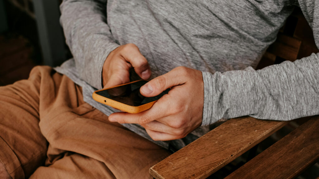 man-sitting-on-a-bench-using-a-cell-phone-bbxh2rl3MvU