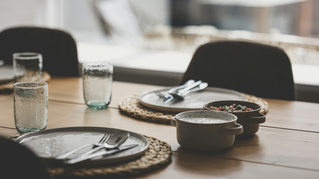 wooden-table-topped-with-plates-and-glasses-ueqjc6WSoRg